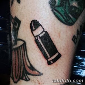 Черно-белое фото тату гильзы, выполненное в минималистичном стиле на руке.