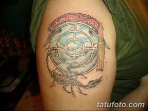 Фото тату на руке: скорпион, мишень и пуля. Цветной рисунок в традиционном стиле.