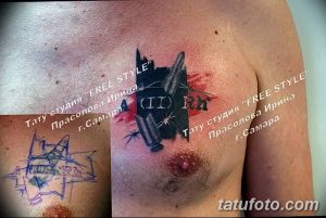 Фотография татуировки на груди с изображением патрона и брызг красной краски. Яркий и динамичный рисунок, символизирующий страсть и энергию.