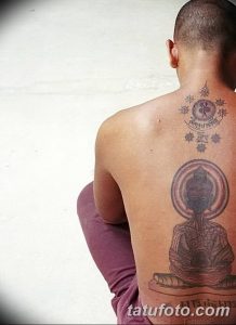 Фото тату на спине с изображением Будды в круге. Черно-серый рисунок с традиционными буддийскими символами и узорами.