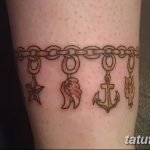 Фото тату в виде браслета с подвесками на щиколотке. Изображены звезда, морской конек, якорь и крест.