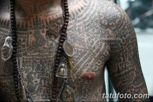 Фото тату в стиле Blackwork, покрывающего большую часть груди и плеч. Черный рисунок татуировки состоит из множества геометрических фигур и религиозных символов.