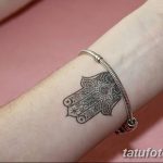 Фото тату на запястье с изображением Хамсы (Руки Фатимы). Черно-белый рисунок с детальной проработкой узоров. Небольшой эскиз татуировки.