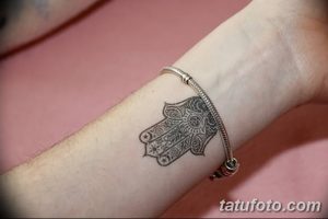 Фото тату на запястье с изображением Хамсы (Руки Фатимы). Черно-белый рисунок с детальной проработкой узоров. Небольшой эскиз татуировки.