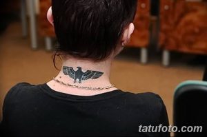 Фото минималистичной татуировки орла на шее мужчины. Черный рисунок, выполненный в простом и элегантном стиле. Стильный эскиз тату.