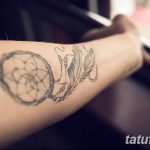 Фото тату: простой ловец снов с пером на предплечье, выполненный в технике тонких линий и точек.