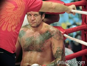 Фото тату на груди бойца MMA: орнамент, темные тона, реалистичный рисунок татуировки, повреждения после боя.