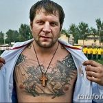 Фото тату на груди бойца MMA: крест, религиозные символы, орнамент, темные тона, реалистичный рисунок татуировки.