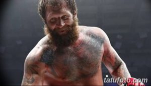 Фото тату на груди бойца MMA: орнамент, темные тона, реалистичный рисунок татуировки, крупный план.