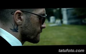 Фото тату: татуировка ласточки на шее мужчины, вид сбоку. Черный рисунок татуировки.