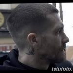 Фото татуировки на шее мужчины: маленькая черная ласточка. Черно-белое изображение, демонстрирующее тату сбоку шеи.