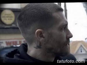 Фото татуировки на шее мужчины: маленькая черная ласточка. Черно-белое изображение, демонстрирующее тату сбоку шеи.