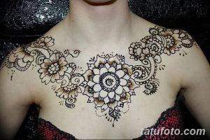 Фото тату мехенди на груди, с использованием коричневых оттенков и цветочных мотивов, демонстрирующее женственность и красоту.