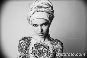 Фото мехенди на теле: крупная мандала в центре и сложные орнаменты, покрывающие плечи и грудь. Идеально для создания загадочного и мистического образа.