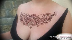 Фото тату хной на груди женщины, выполненное в восточном стиле с использованием сложных узоров и растительных мотивов. Идеально для вдохновения.