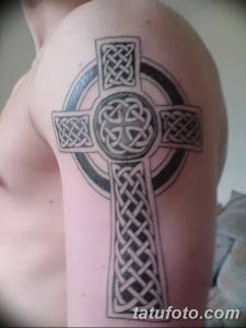 Фото татуировки кельтского креста на плече, выполненной в технике blackwork с использованием геометрических узоров.