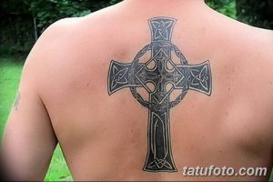 Фото тату кельтского креста на лопатке. Черно-серый рисунок татуировки с детализированными кельтскими узорами и четкими линиями.