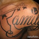 Фото татуировки с надписью 'Family' выполненной красивым шрифтом, украшенной флагом и звездами. Расположена на плече.