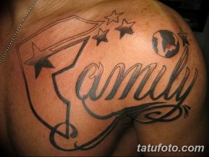 Фото татуировки с надписью 'Family' выполненной красивым шрифтом, украшенной флагом и звездами. Расположена на плече.