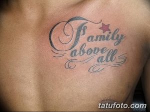 Фото тату надпись 'Family above all' на груди мужчины. Серые тона, каллиграфический шрифт, маленькая звездочка.