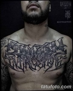 Фото тату с надписью 'Forever Over Everything' в готическом стиле на груди и шее мужчины.