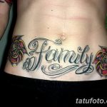 Фото тату с надписью 'Family' в каллиграфическом стиле, обрамленной двумя красными розами на женской талии.