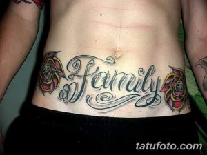 Фото тату с надписью 'Family' в каллиграфическом стиле, обрамленной двумя красными розами на женской талии.