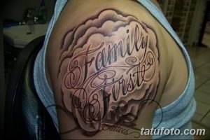 Фото тату на плече: надпись 'Family First' в каллиграфическом стиле, окруженная облаками и декоративными элементами.