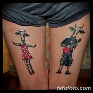Фото тату на бедрах с изображением двух забавных коз: одна в платье играет на гитаре, другая просто стоит. Цветная татуировка.
