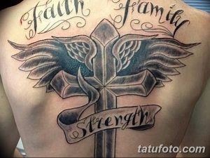 Фото тату на спине с изображением креста с крыльями, окруженного надписями 'Faith', 'Family', 'Strength'. Черно-серая татуировка.