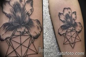 Фото татуировки на руке с изображением цветка ириса, заключенного в геометрическую фигуру. Рисунок выполнен в черно-серых тонах с использованием штриховки.