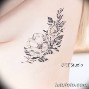 Фото тату роз на ключице. Изображение нескольких бутонов роз с листьями и стеблями. Черно-белое исполнение, акцент на детализацию и плавные линии.
