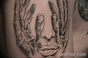 Фото тату на плече, изображающее руки, словно обнимающие лицо. Реалистичная проработка деталей, тени и текстуры кожи создают эффект присутствия.