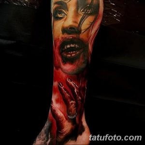 Фото татуировки на всю руку с изображением лица вампирши, залитого кровью, выполненной в реалистичном стиле.