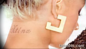 Фото татуировки с надписью "Xtina" на задней части шеи. Простой, минималистичный рисунок татуировки, выполненный черными чернилами.