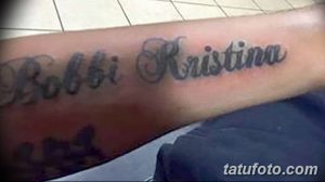 Фото тату надписи 'Bobbi Kristina' на предплечье. Черно-серый рисунок татуировки, выполненный каллиграфическим шрифтом, символизирует память и любовь.