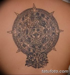 Фото тату на спине: изображение календаря ацтеков, выполненное в технике blackwork с четкими линиями и геометрическими узорами.