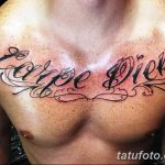 Фото тату надписи 'Carpe Diem' на груди мужчины. Черная каллиграфическая надпись с декоративными элементами, выполненная в классическом стиле.