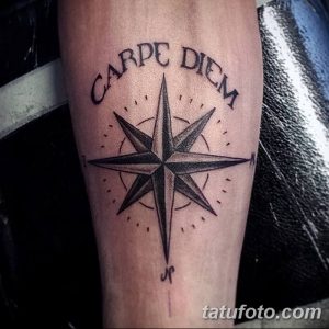 Фотография татуировки на предплечье с изображением компаса и надписью 'Carpe Diem'. Черно-белый рисунок с четкими линиями и детальной проработкой.