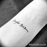 Фотография минималистичной татуировки 'Carpe Diem' на руке. Тонкие линии и простой шрифт создают элегантный и ненавязчивый дизайн.