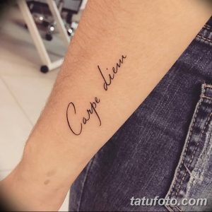 Фото тату: простая и элегантная надпись 'Carpe Diem' на руке, выполненная тонкой линией. Минималистичный стиль.