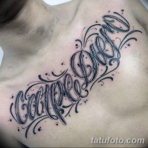 Фото элегантной татуировки 'Carpe Diem' на груди мужчины, выполненной в черном цвете с декоративными элементами. Детализированный рисунок татуировки.