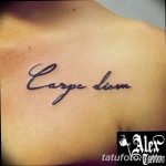 Фото татуировки 'Carpe Diem' на ключице. Черно-серая надпись, выполненная изящным каллиграфическим шрифтом.
