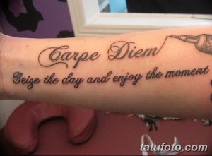 Фото татуировки 'Carpe Diem' на предплечье. Простая, черно-серая надпись с дополнительной фразой на английском.