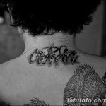 Фото тату надписи 'Carpe Diem' на затылке, выполненной в современном стиле. Черно-серая татуировка с динамичными линиями и необычным расположением.