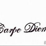 Фото тату надписи 'Carpe Diem' с добавлением стилизованных крыльев по бокам. Черно-белая татуировка, выполненная в графическом стиле.