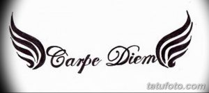 Фото тату надписи 'Carpe Diem' с добавлением стилизованных крыльев по бокам. Черно-белая татуировка, выполненная в графическом стиле.