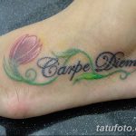 Красочная татуировка надписи 'Carpe Diem' и цветка тюльпана на стопе женщины. Нежные пастельные тона и изящный дизайн.