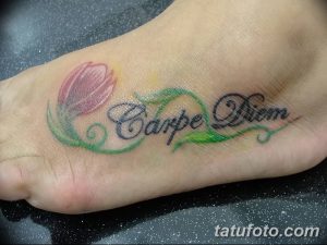 Красочная татуировка надписи 'Carpe Diem' и цветка тюльпана на стопе женщины. Нежные пастельные тона и изящный дизайн.
