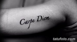 Простая и лаконичная татуировка надписи 'Carpe Diem' черным цветом на внутренней стороне предплечья. Идеально для любителей минимализма.